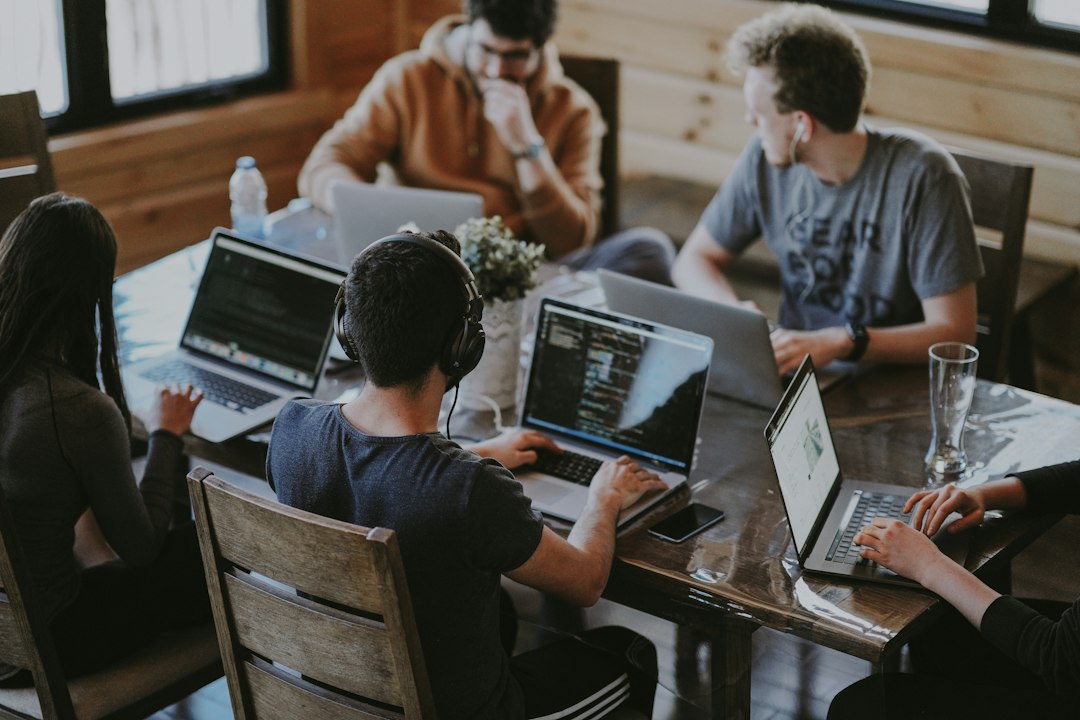 Team arbeitet gemeinsam mit Laptops an einem Tisch und entwickelt Ideen